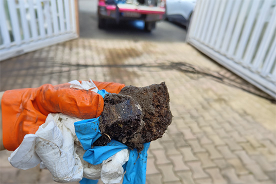 Photo d'un bouchon de canalisation extrait lors d'une intervention de débouchage dans un regard, par la Compagnie des Déboucheurs